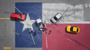 Gen4-graphicTexasflagwithcaraccidents | V.Valenzuela Law | V.Valenzuela Law Aerial view of a multi-car crash on a color-blocked road, with a red car on the left, a blue car center, a white car nearby, and a yellow car on the red section; two people stand near the blue car amid scattered debris.